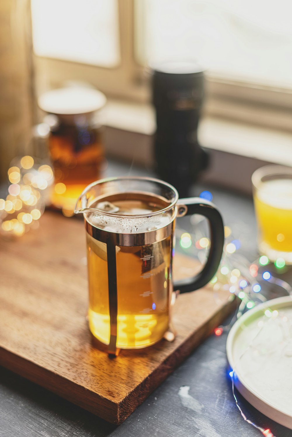 clear glass mug with brown liquid on brown wooden table