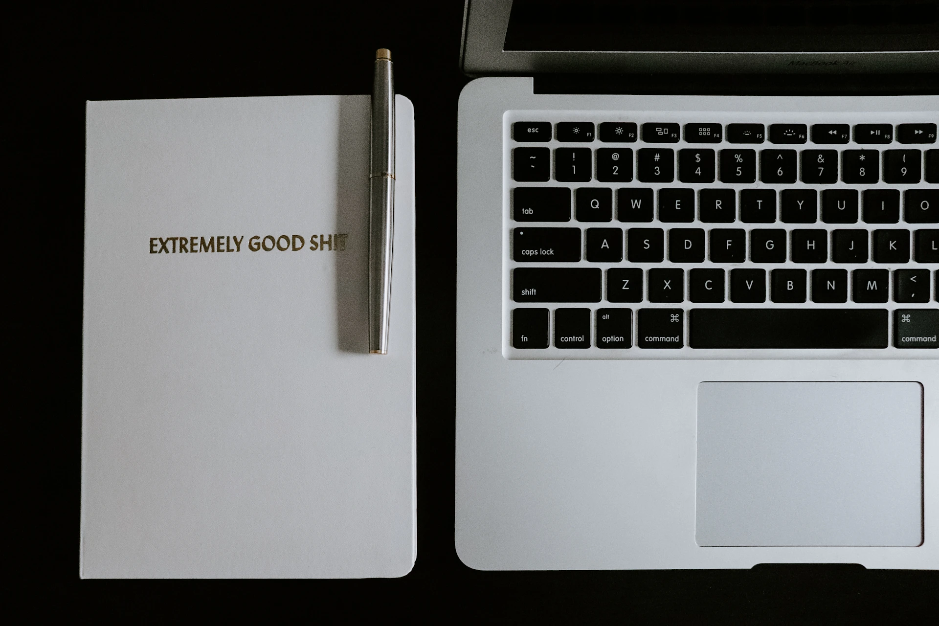 macbook pro beside black pen