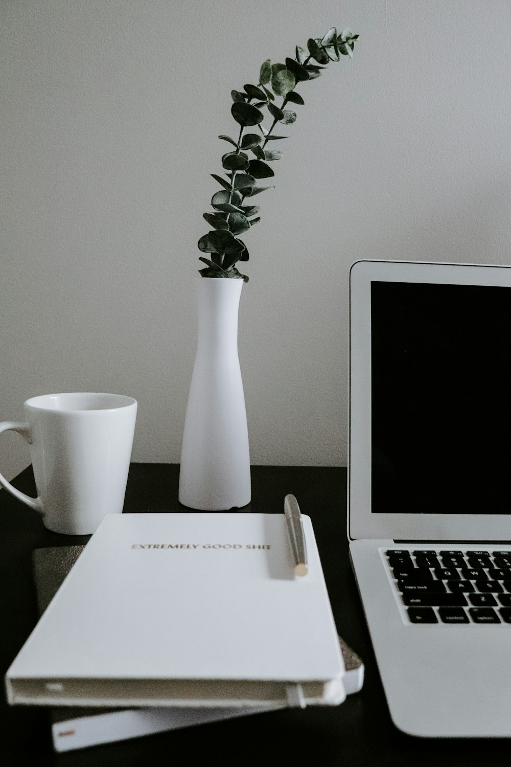 white ceramic mug beside macbook air