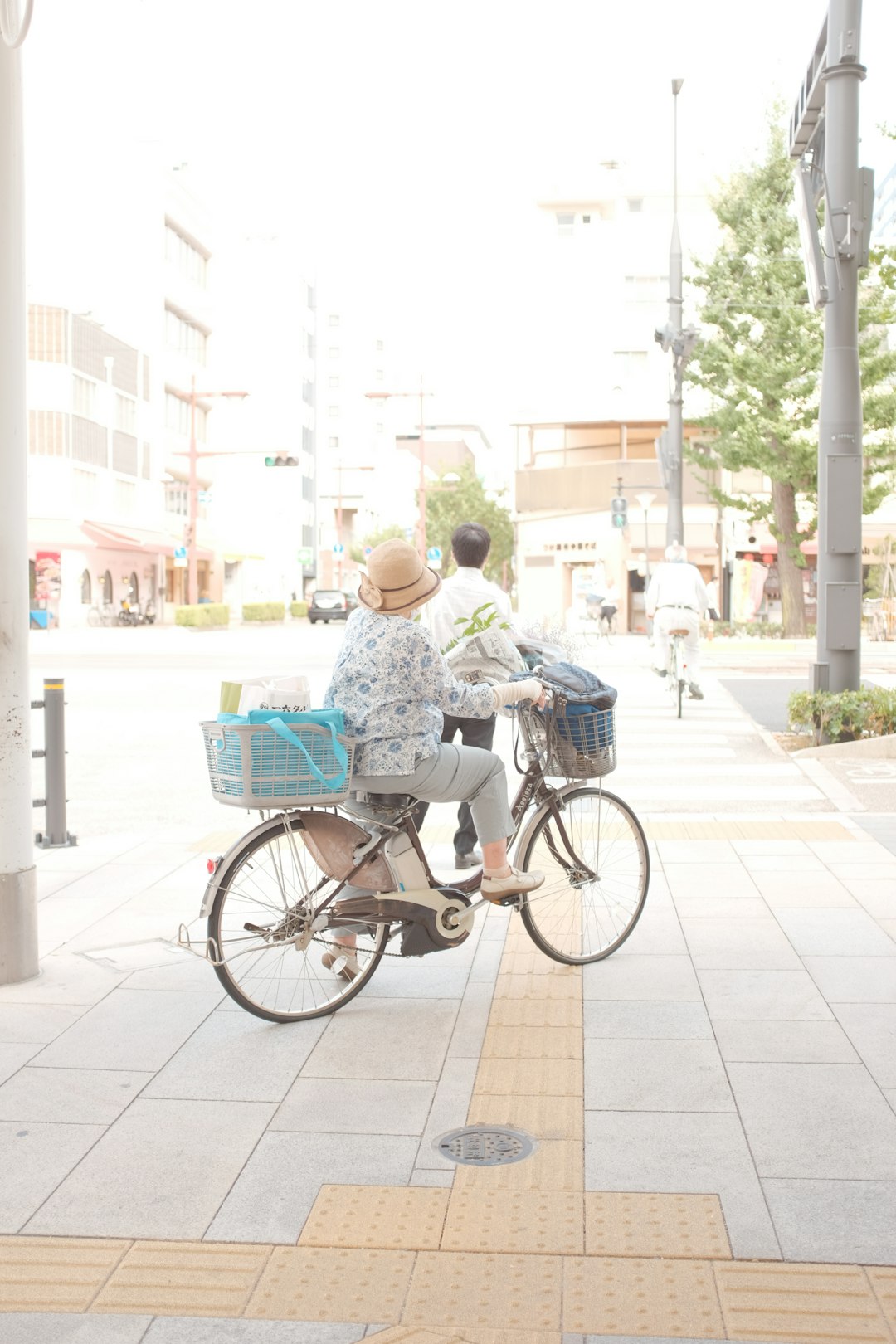 man in blue and white floral shirt riding on black city bicycle during daytime