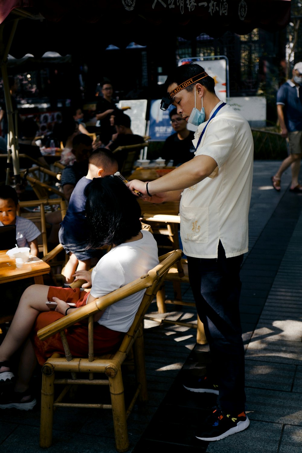 man in white t-shirt and black pants standing near brown wooden table