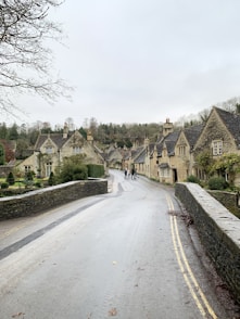 gray concrete road between houses during daytime