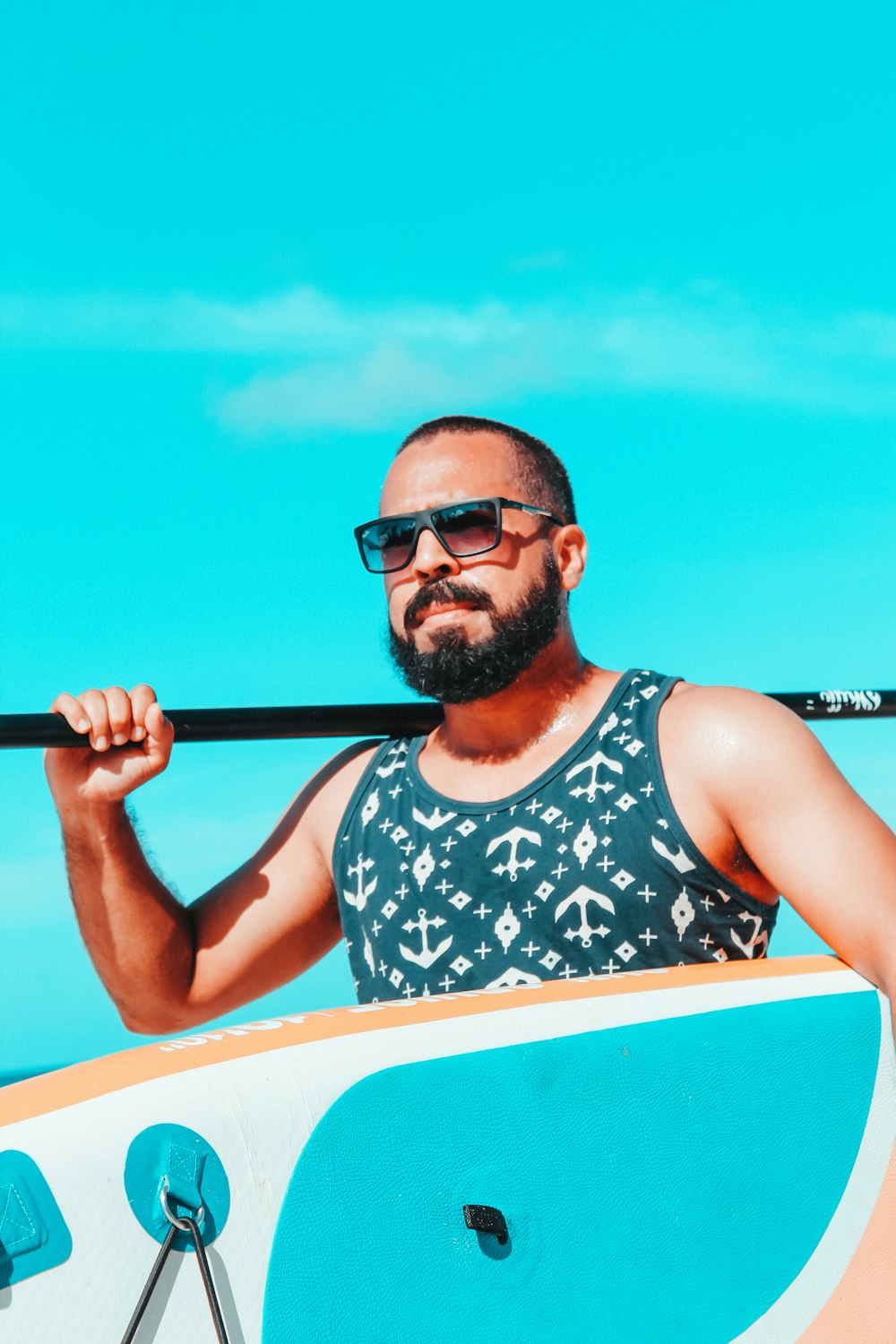 man in black and white floral tank top wearing black sunglasses