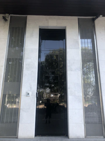 Close-up of a matte black Stilex steel door featuring brushed steel accents and a secure multi-point locking system.