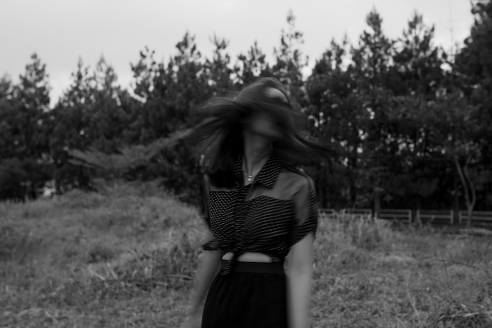 woman in black and white stripe shirt standing on grass field