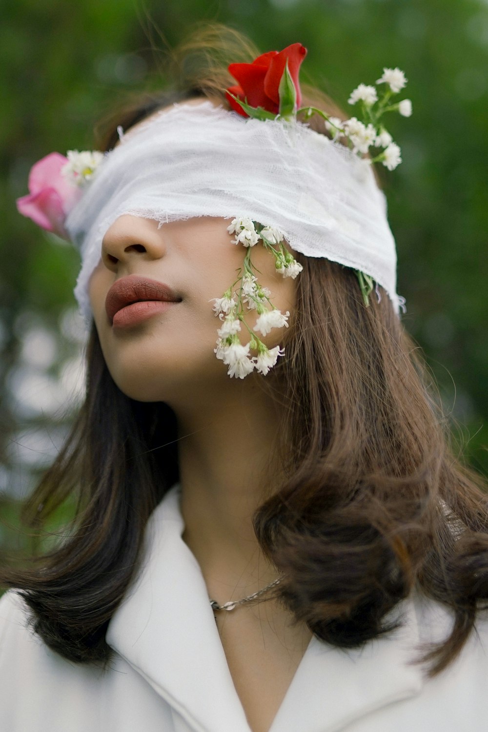 Frau in weißem geblümtem Kopfkleid mit weißer Blume auf dem Kopf