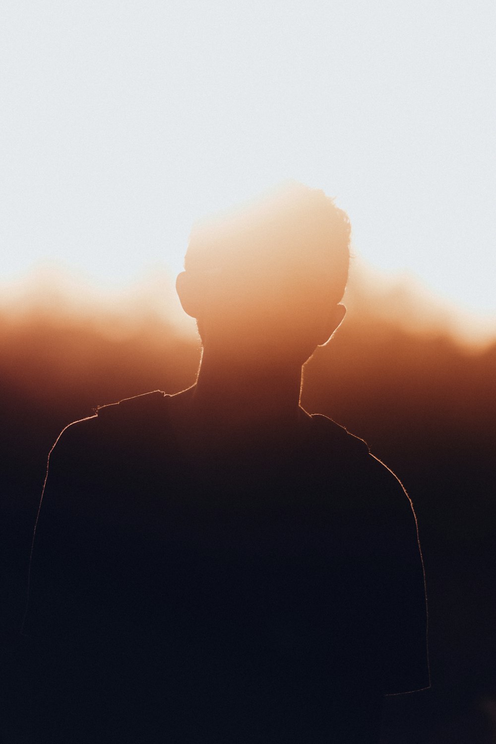 Silueta del hombre en chaqueta negra durante la puesta del sol