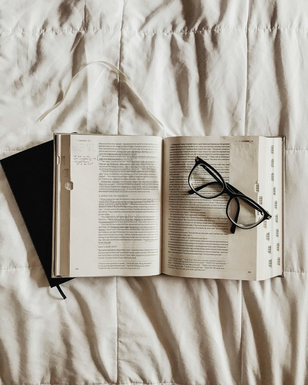 black framed eyeglasses on white book page