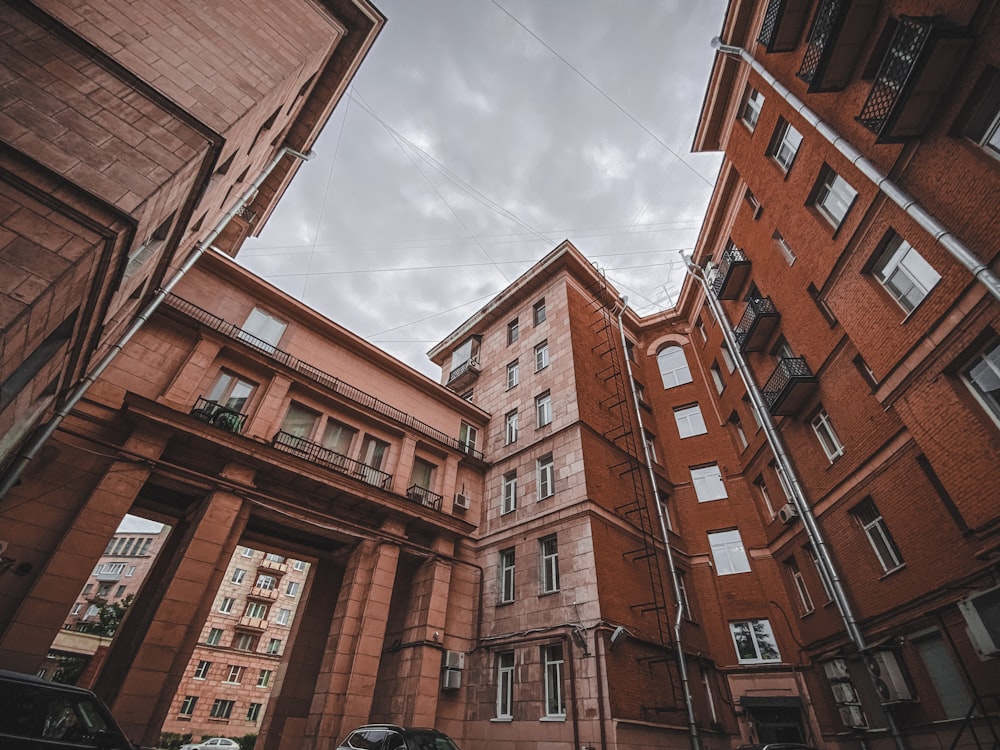 brown concrete building under white clouds and blue sky during daytime