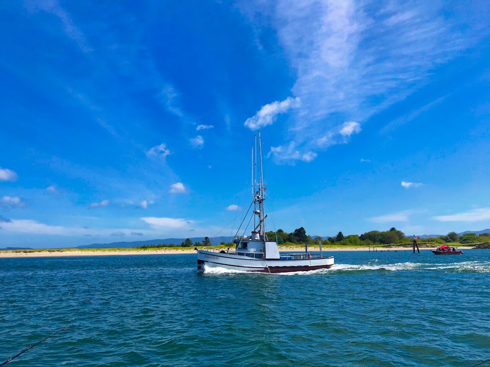 white boat on sea under blue sky during daytime