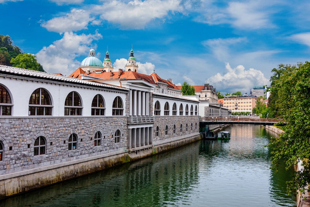 white and brown concrete building beside river under blue sky during daytime