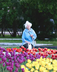 woman in blue jacket standing on flower field during daytime