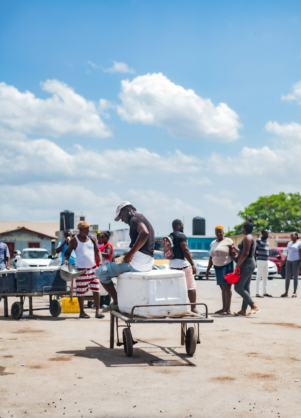 people standing and sitting on white and blue cart during daytime