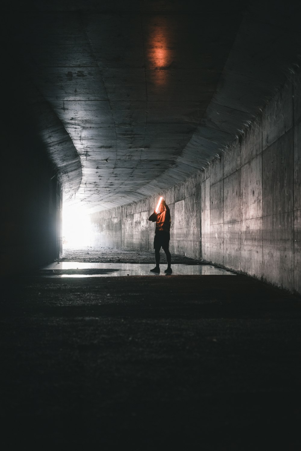 woman in red shirt walking on tunnel