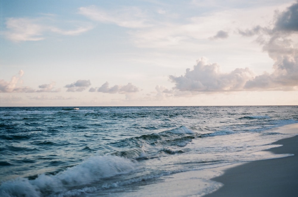 ocean waves crashing on shore during daytime