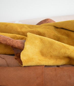 yellow textile on brown couch