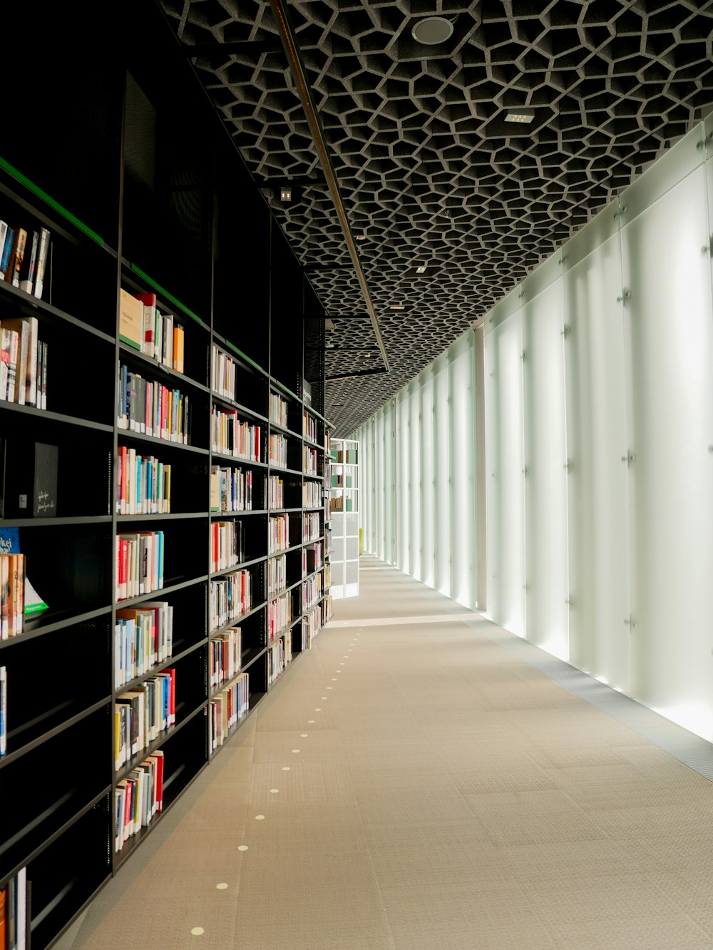 white wooden book shelves on white concrete wall