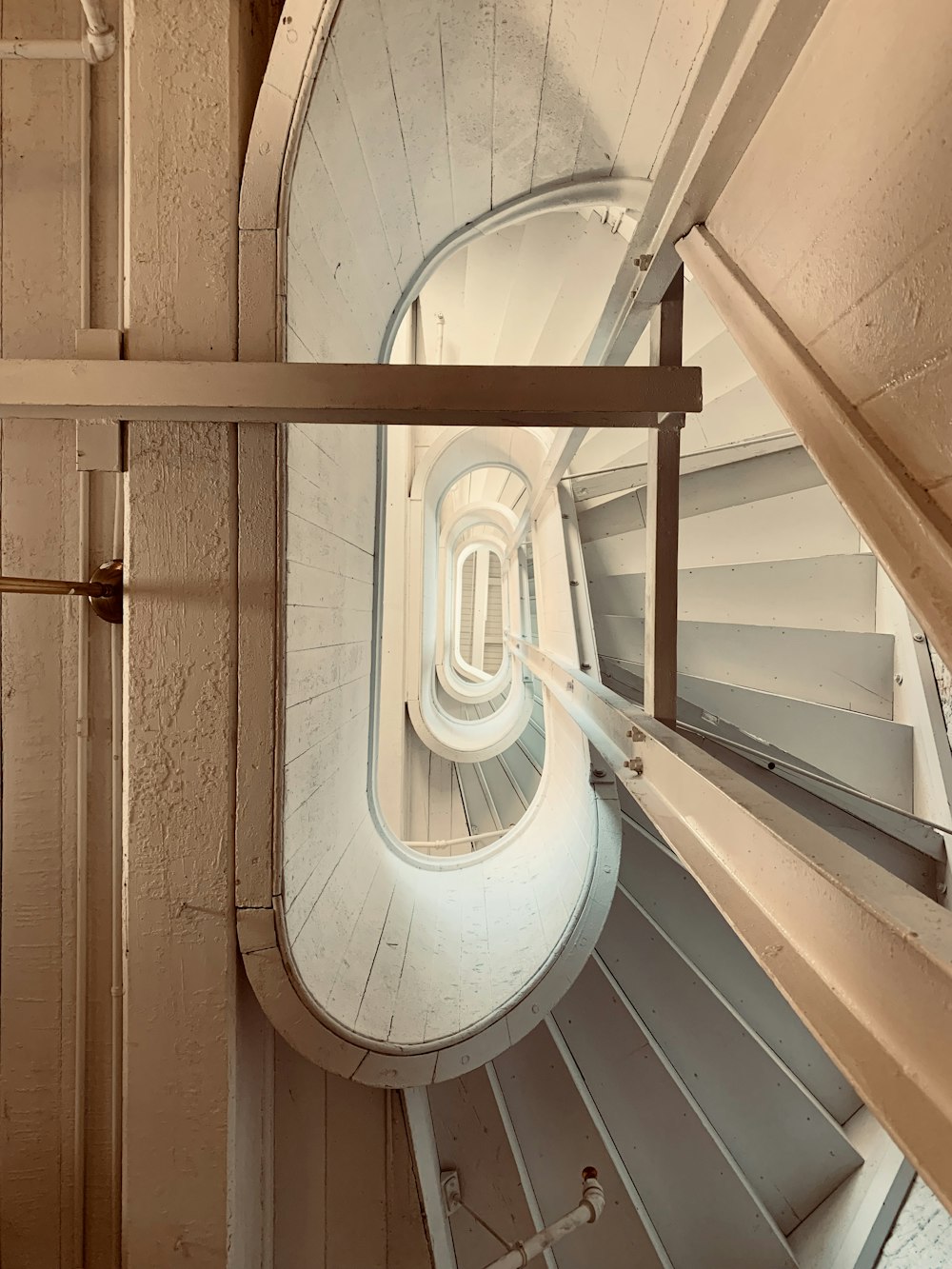 white spiral staircase with brown wooden door