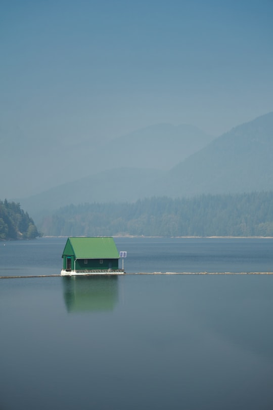 green and white house on lake during daytime in Capilano River Regional Park Canada