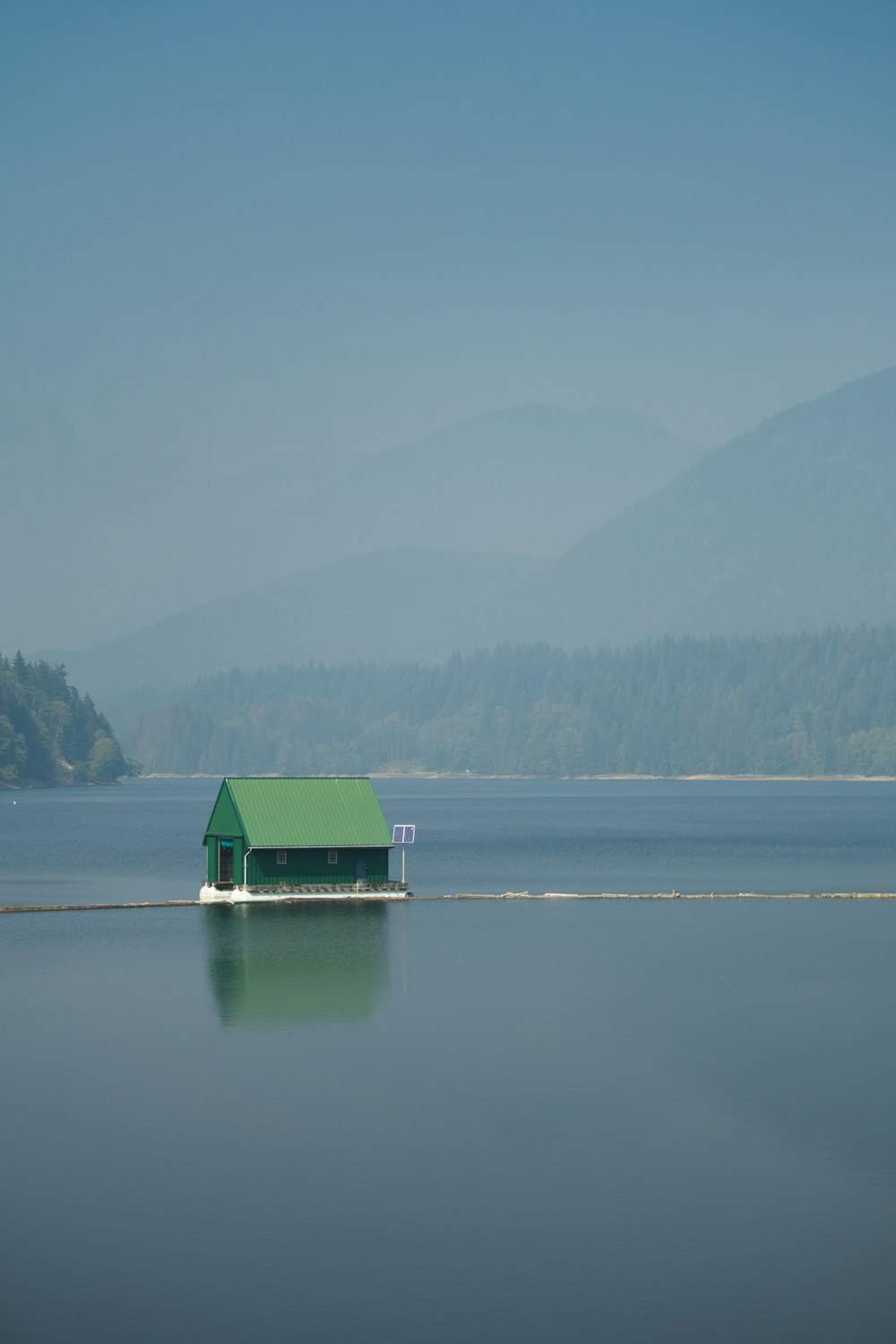 green and white house on lake during daytime