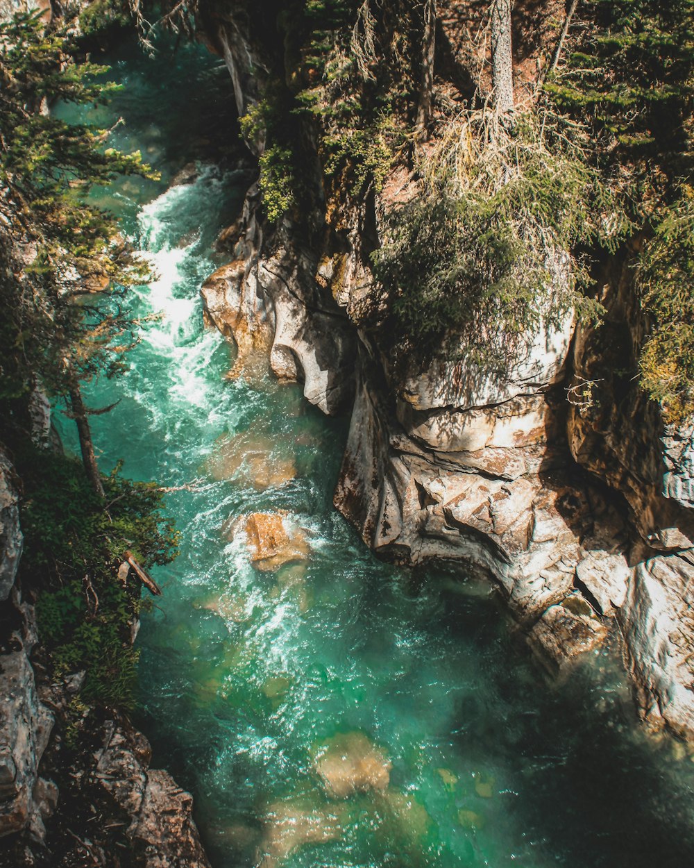 body of water between brown and gray rock formation during daytime