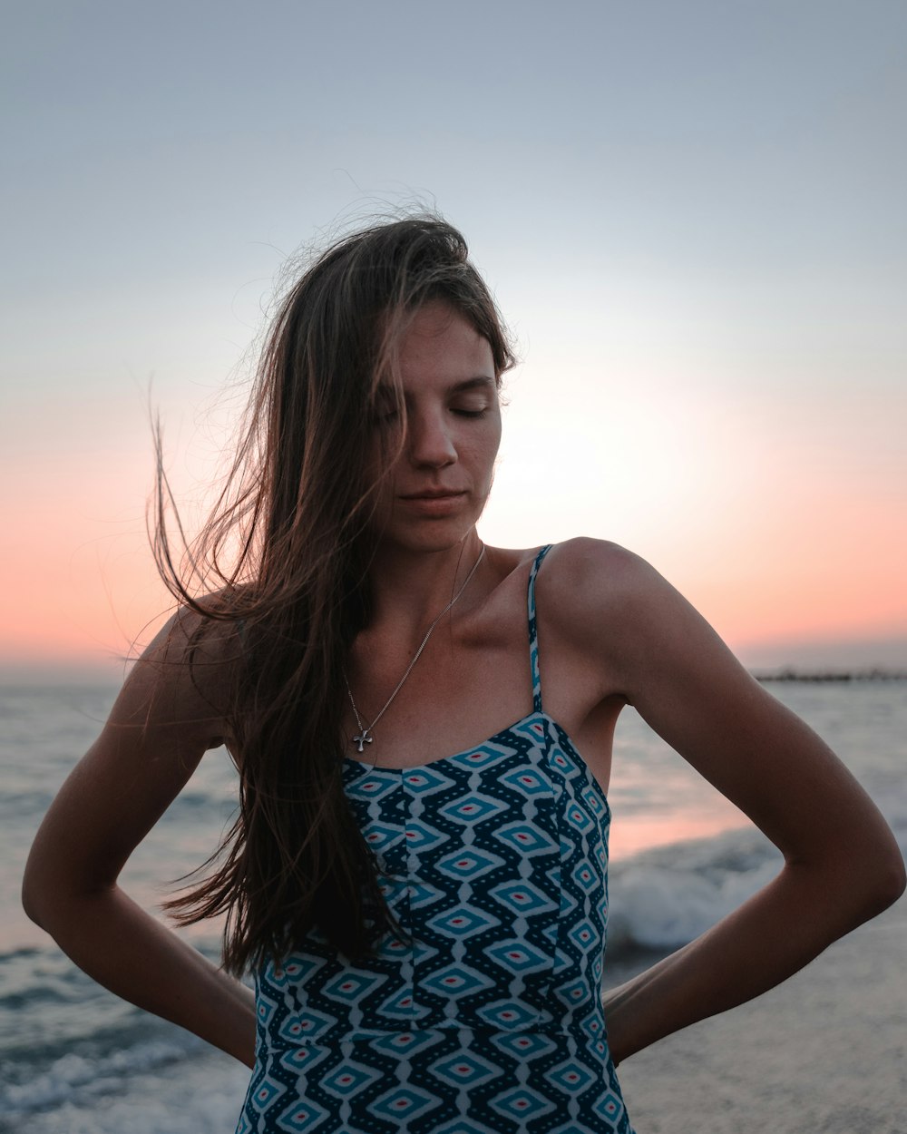 woman in blue and white spaghetti strap top smiling