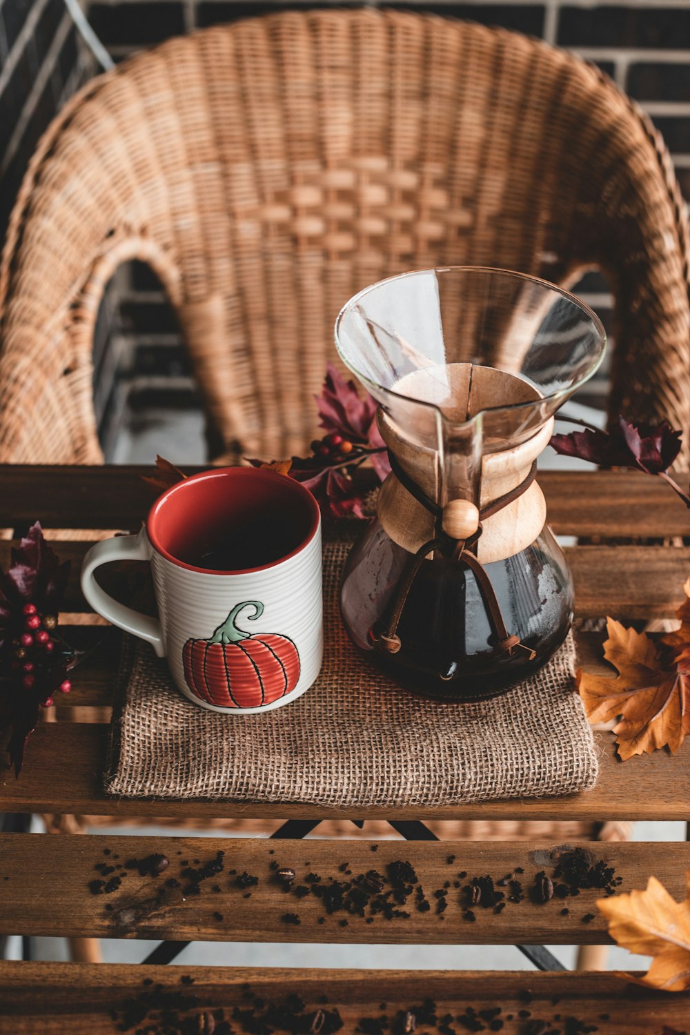 white and red ceramic mug beside black and clear glass coffee pot