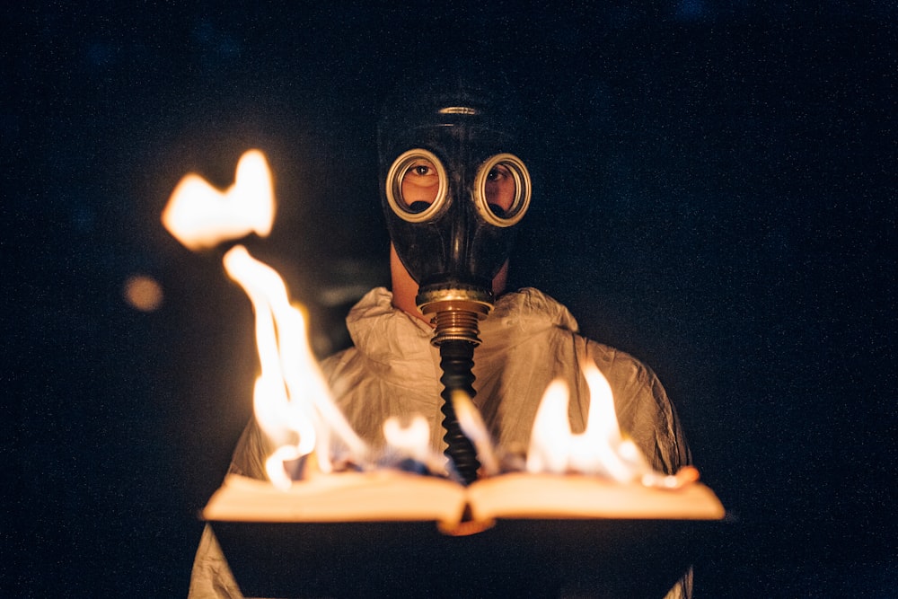 person wearing gas mask holding fire