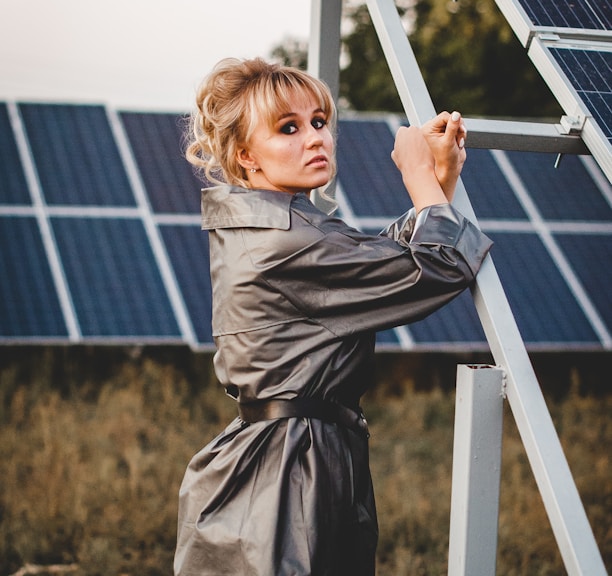 girl in gray coat standing near solar panels during daytime