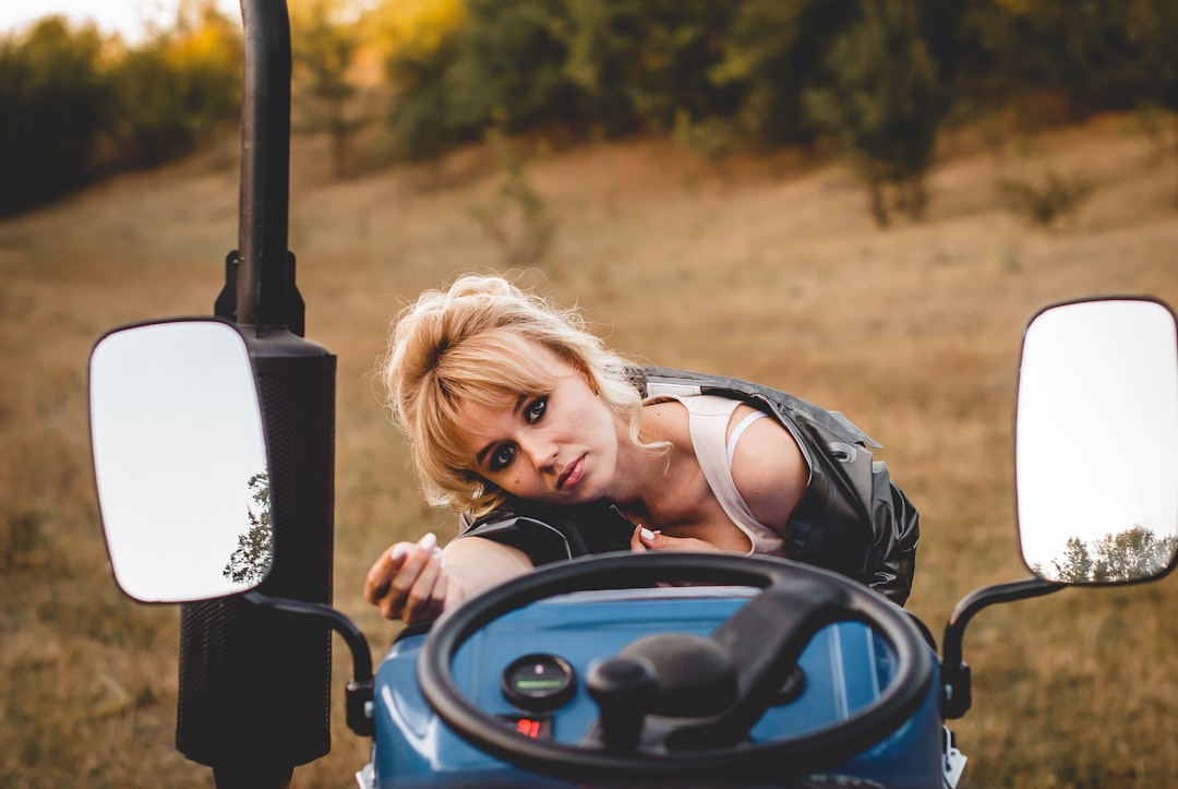 woman in black tank top riding on blue and black ride on toy car