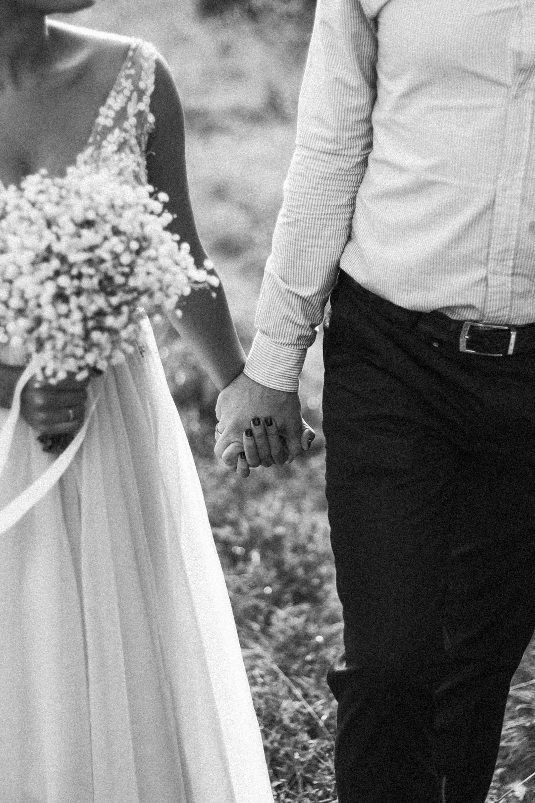 grayscale photo of man and woman holding bouquet of flowers