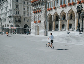 man in white shirt riding bicycle on road during daytime