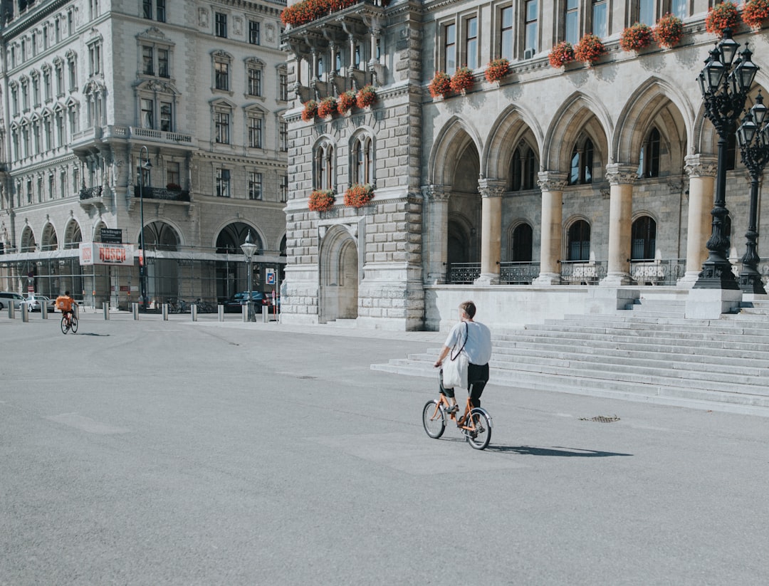 man in white shirt riding bicycle on road during daytime