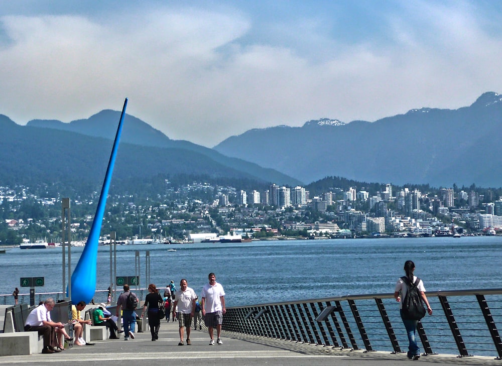 people walking on wooden dock near body of water during daytime