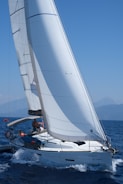 Sailboats navigating through clear blue sea under bright sky