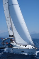 Sailboats navigating through clear blue sea under bright sky