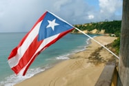 red and white flag on beach shore during daytime