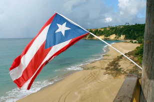 red and white flag on beach shore during daytime