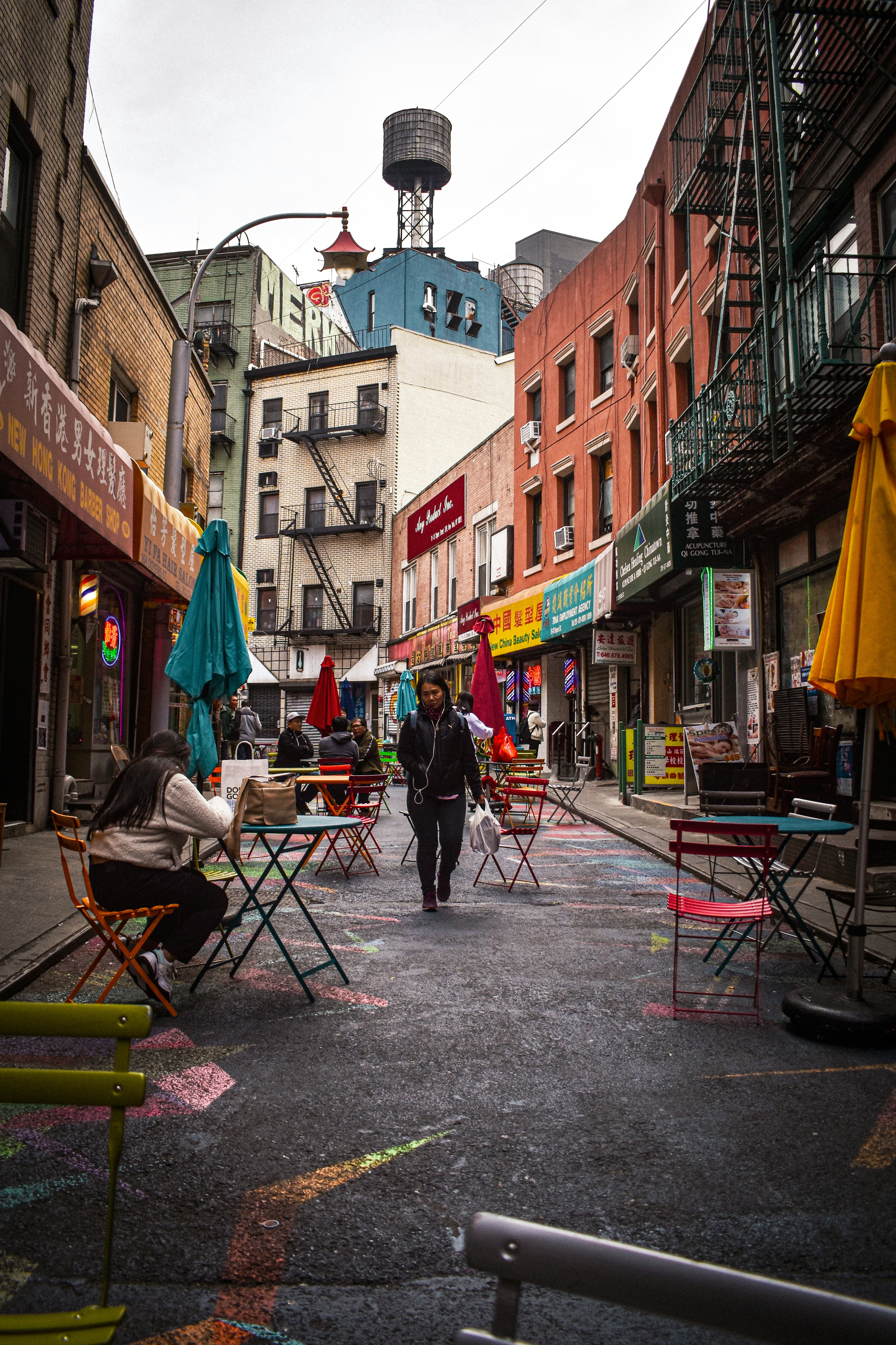 man in blue shirt and blue denim jeans sitting on red folding chair during daytime