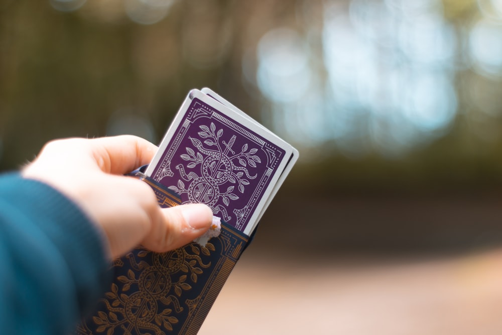 person holding blue and white playing card