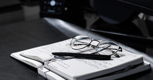 black framed eyeglasses on white paper