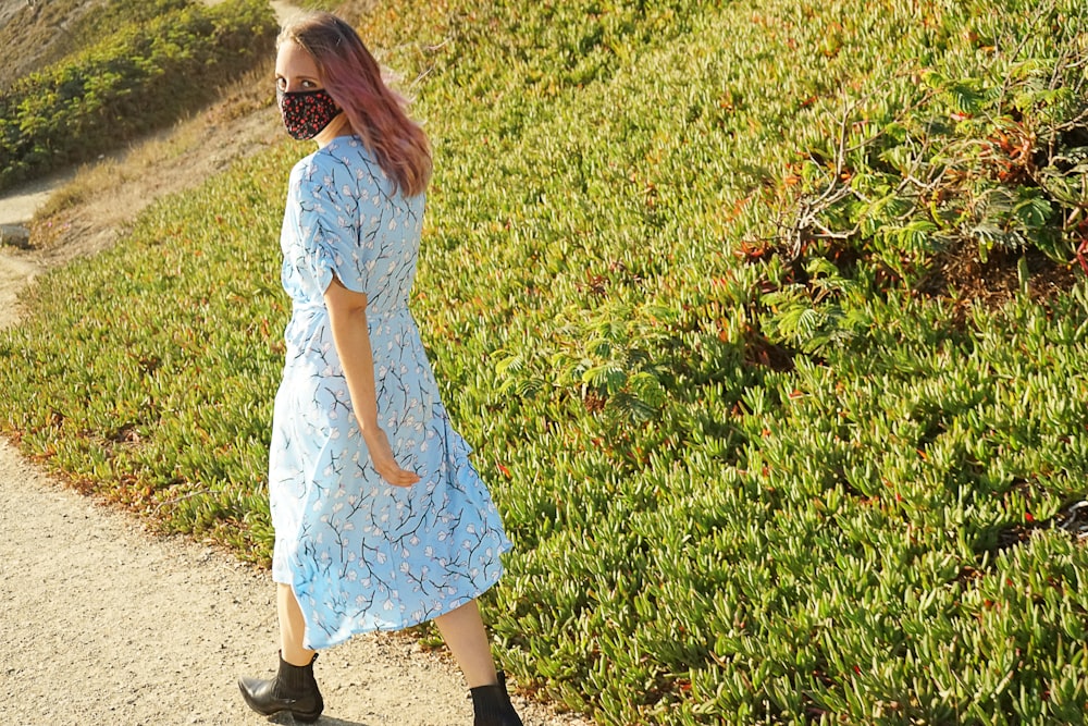 girl in white dress standing on green grass field during daytime