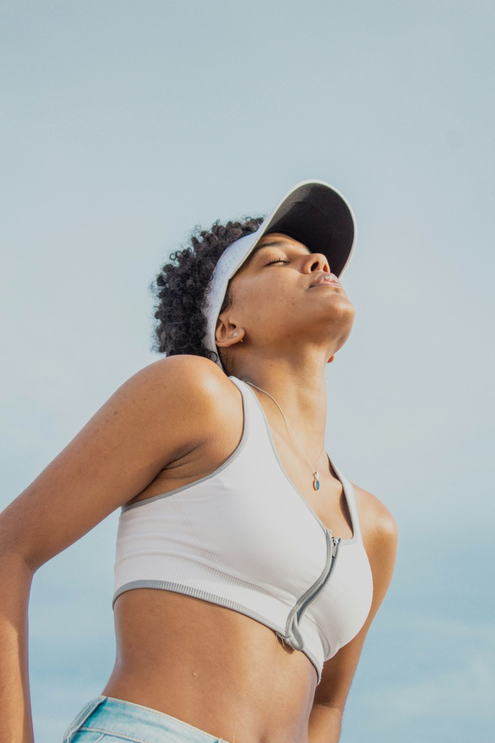 woman in white tank top and black cap