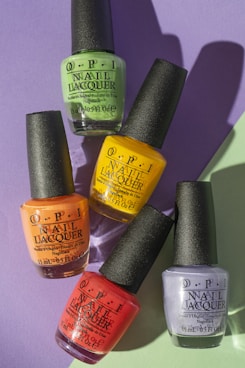 six nail polish bottles on purple surface