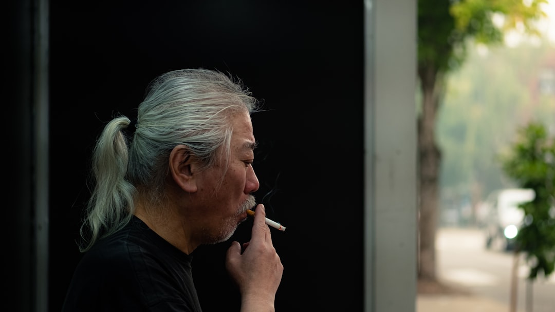 man in black crew neck shirt smoking cigarette