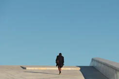 man in black jacket standing on gray concrete floor during daytime