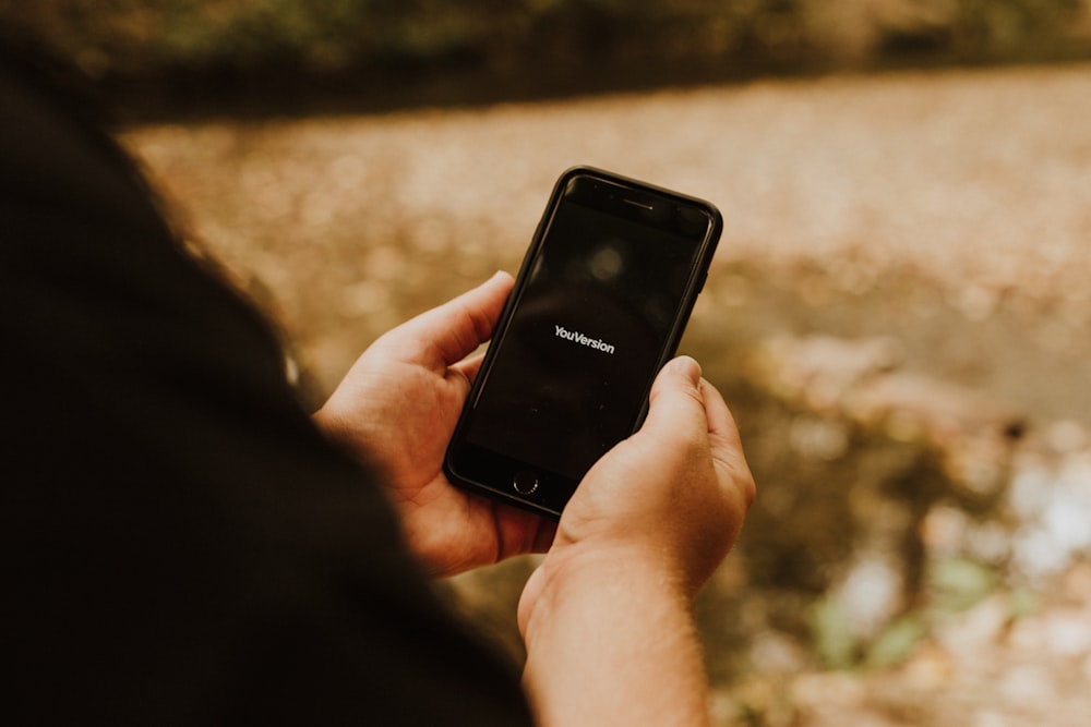 person holding black iphone 4