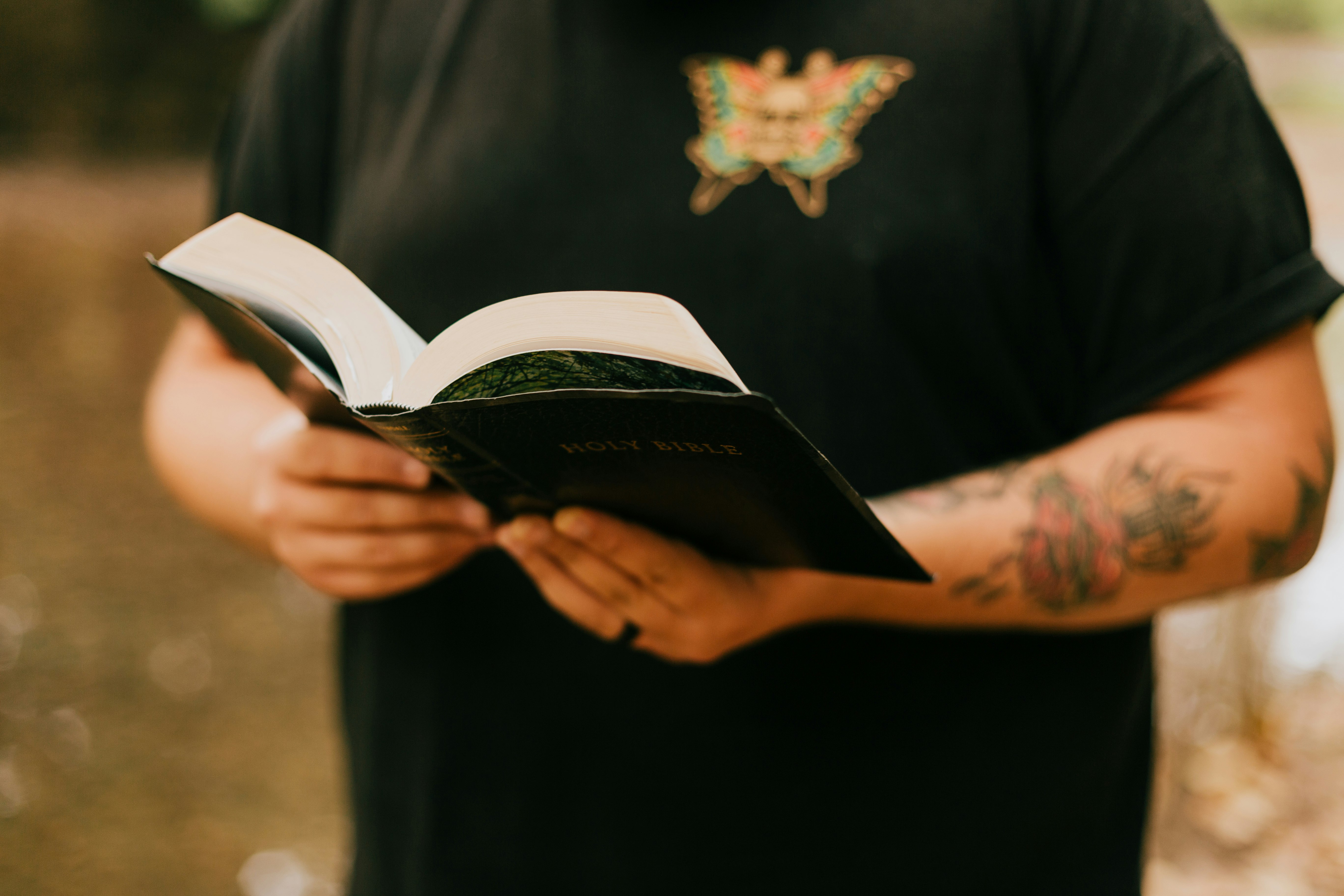 person in black robe holding white book