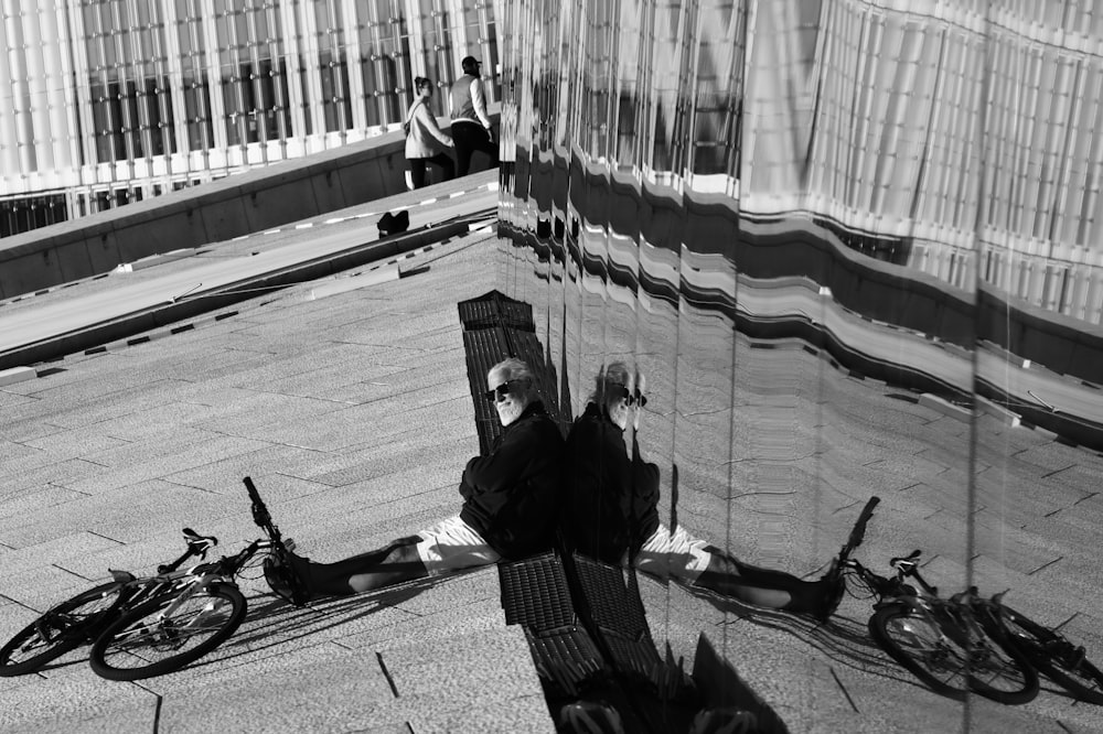 a reflection of a person sitting on a bench