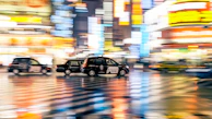 Night cityscape with multiple taxis moving smoothly on illuminated roads.